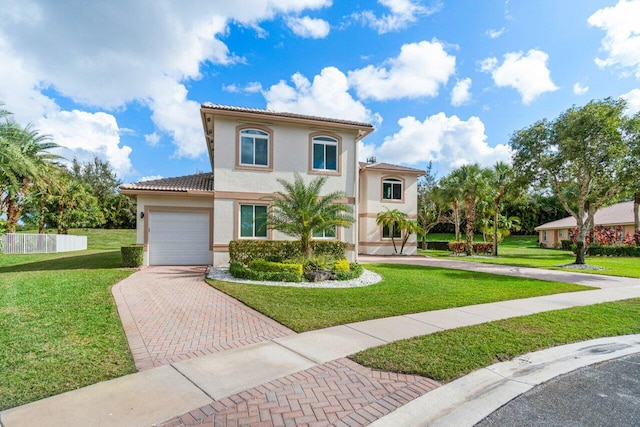 mediterranean / spanish house with a garage and a front lawn