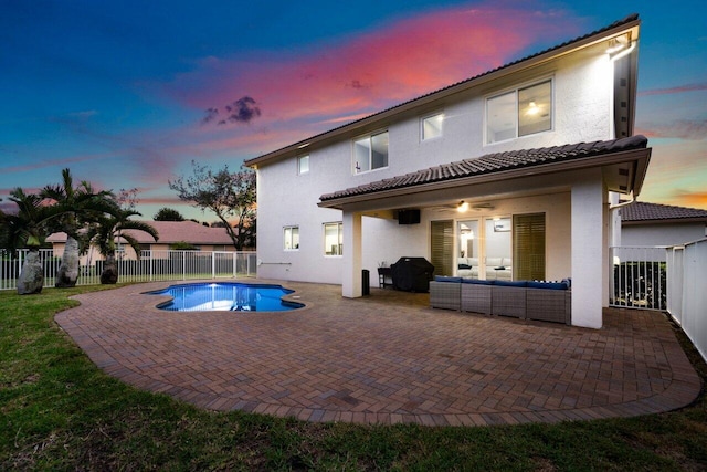 back house at dusk with a fenced in pool, a patio area, ceiling fan, and outdoor lounge area