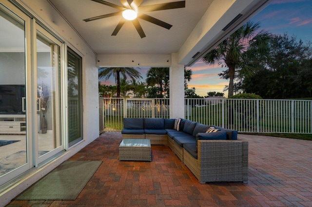 patio terrace at dusk with outdoor lounge area and ceiling fan