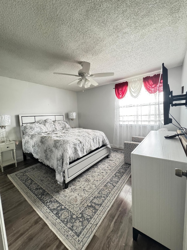 bedroom with ceiling fan, dark hardwood / wood-style flooring, and a textured ceiling