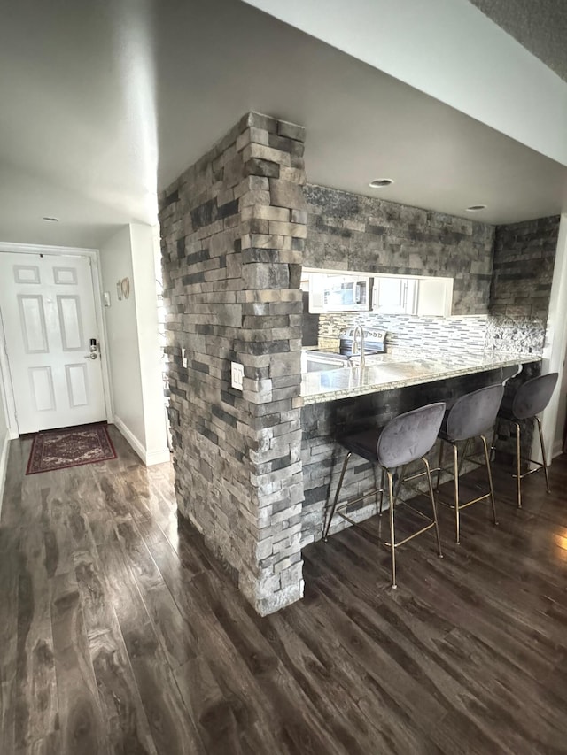 bar with white cabinetry, sink, electric range, dark hardwood / wood-style floors, and decorative backsplash