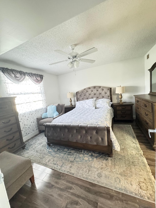 bedroom featuring ceiling fan, dark wood-type flooring, and a textured ceiling