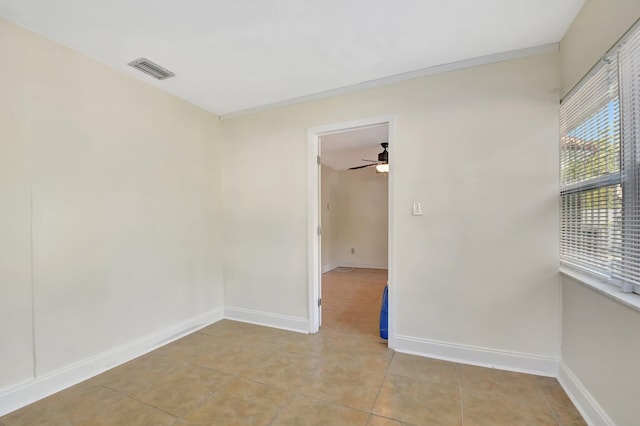 tiled spare room featuring ceiling fan