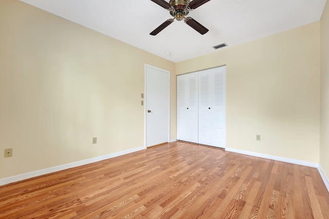 unfurnished bedroom featuring ceiling fan, a closet, and light hardwood / wood-style flooring