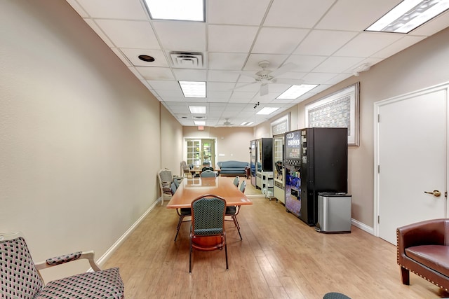 dining space featuring a drop ceiling, light hardwood / wood-style floors, and ceiling fan