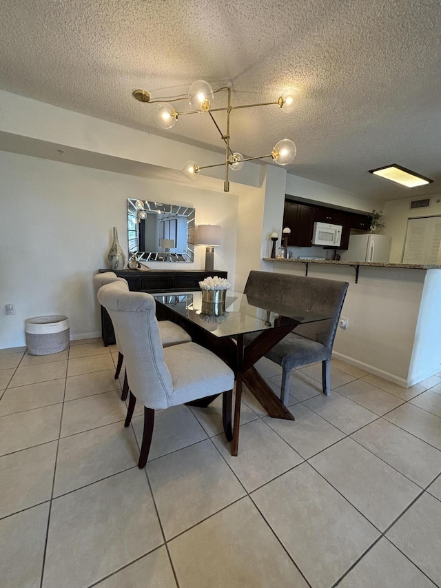 tiled dining room featuring a textured ceiling