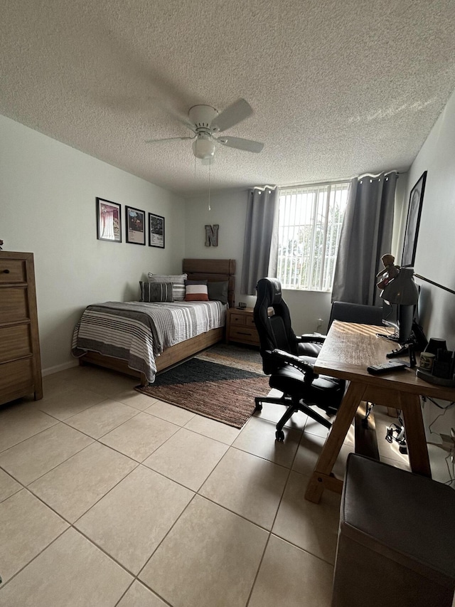 tiled bedroom with ceiling fan and a textured ceiling