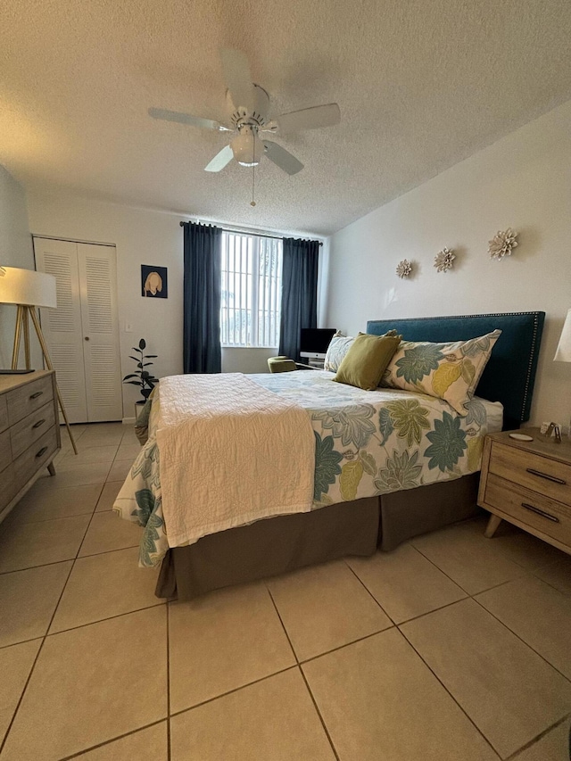 tiled bedroom featuring a textured ceiling, a closet, and ceiling fan