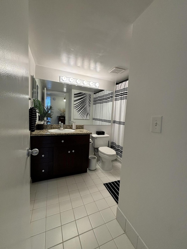 bathroom featuring tile patterned flooring, vanity, and toilet