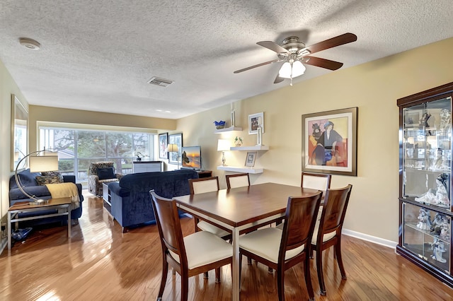 dining space featuring light wood-type flooring and ceiling fan