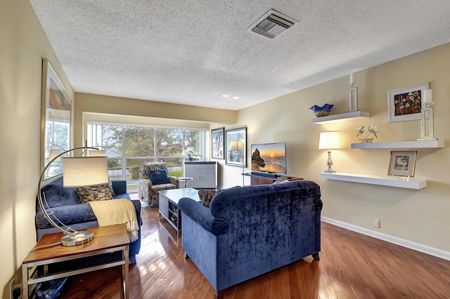 living room with hardwood / wood-style flooring and a textured ceiling