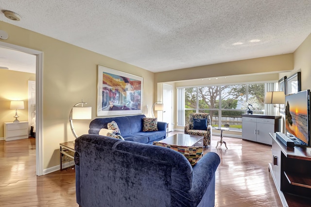 living room with a textured ceiling and light wood-type flooring