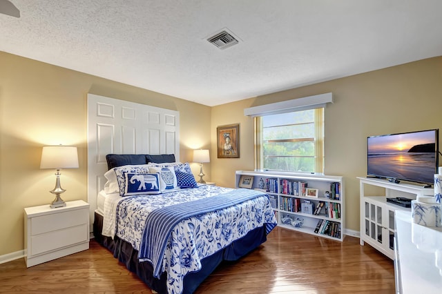 bedroom featuring wood-type flooring and a textured ceiling