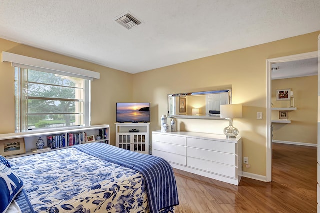 bedroom featuring a textured ceiling and light wood-type flooring