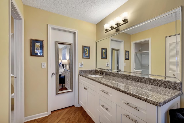 bathroom with vanity, a textured ceiling, and hardwood / wood-style flooring