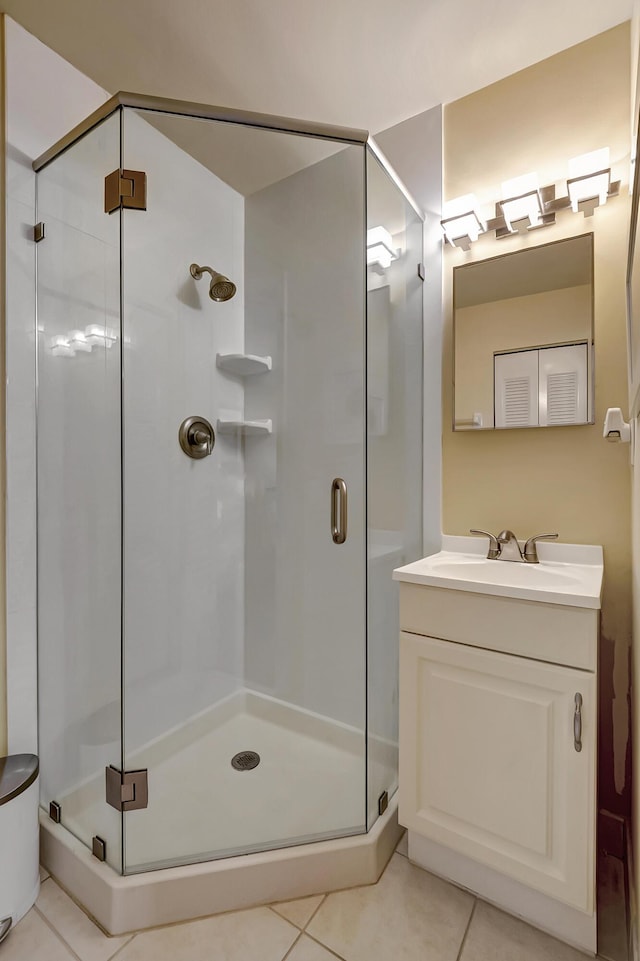 bathroom featuring tile patterned flooring, vanity, and walk in shower