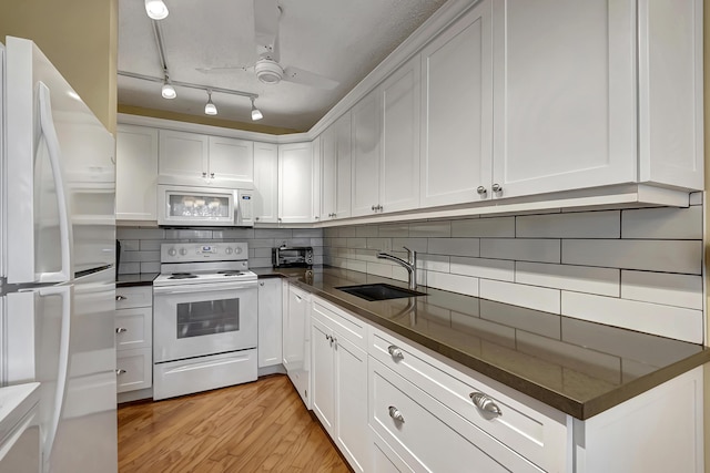 kitchen featuring white appliances, white cabinetry, and sink