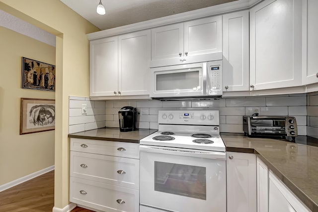 kitchen featuring hardwood / wood-style floors, a textured ceiling, white appliances, decorative backsplash, and white cabinets