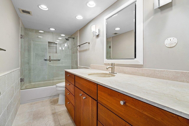 full bathroom with vanity, toilet, and bath / shower combo with glass door