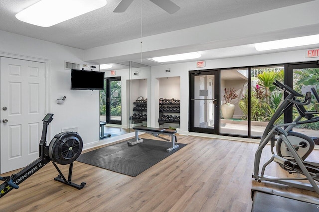 gym with wood-type flooring, a textured ceiling, and ceiling fan