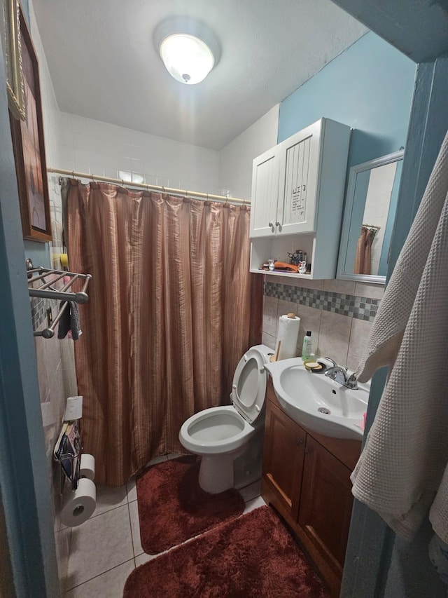 bathroom featuring backsplash, vanity, tile patterned flooring, toilet, and curtained shower