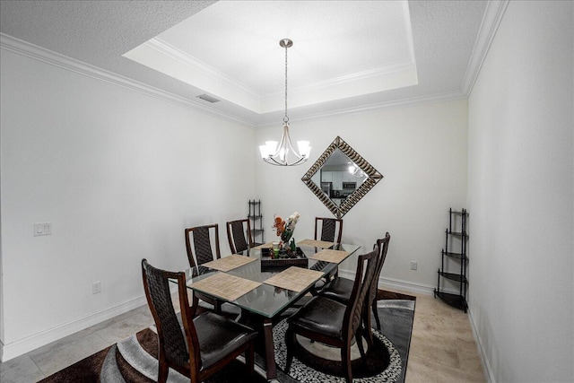 tiled dining room with a raised ceiling, ornamental molding, a textured ceiling, and an inviting chandelier