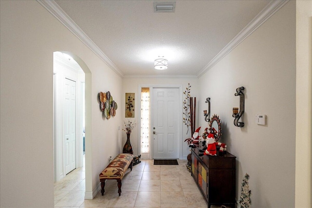 tiled foyer featuring a textured ceiling and ornamental molding