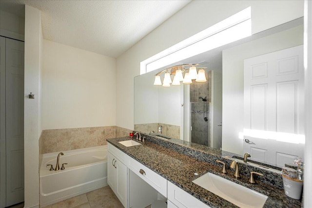 bathroom with tile patterned floors, vanity, a textured ceiling, and plus walk in shower