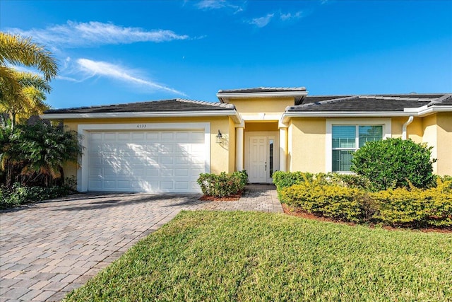 view of front of property with a garage and a front lawn