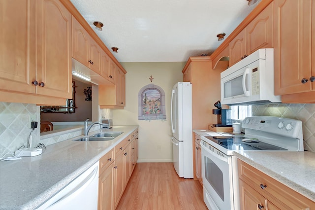 kitchen featuring light brown cabinets, white appliances, sink, tasteful backsplash, and light hardwood / wood-style floors