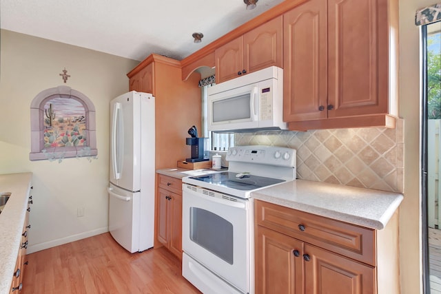 kitchen featuring decorative backsplash, white appliances, and light wood-type flooring