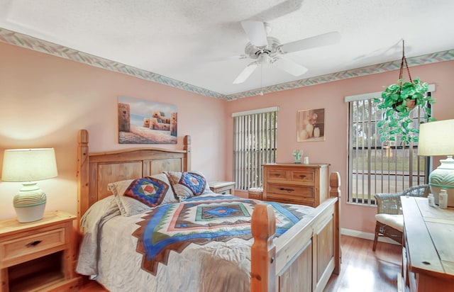 bedroom featuring ceiling fan, light hardwood / wood-style floors, and a textured ceiling