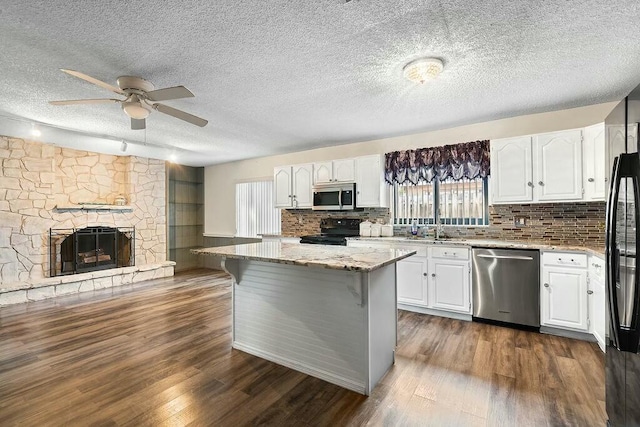 kitchen featuring black appliances, a center island, and white cabinetry