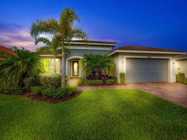 mediterranean / spanish-style home featuring a yard and a garage