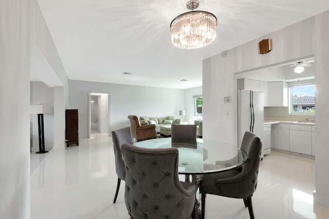 dining area with a healthy amount of sunlight, sink, and a chandelier