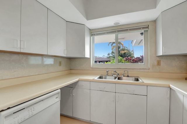 kitchen with backsplash, white cabinetry, sink, and white dishwasher