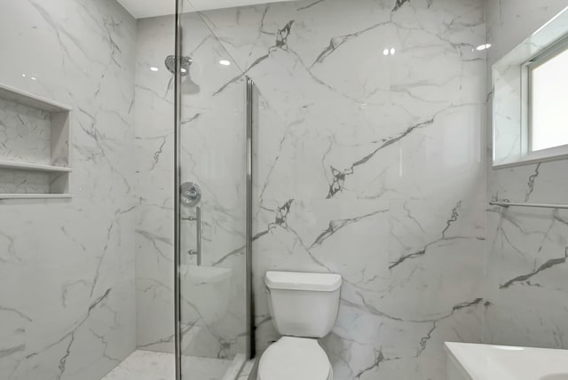 bathroom featuring a tile shower and toilet