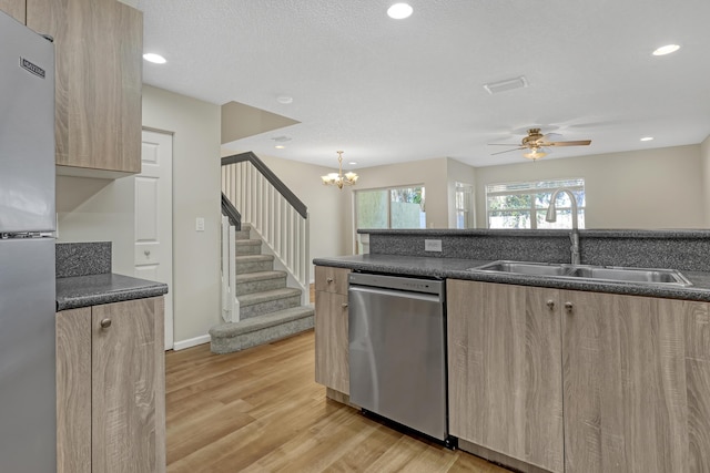 kitchen with sink, light brown cabinets, stainless steel appliances, light hardwood / wood-style flooring, and ceiling fan with notable chandelier