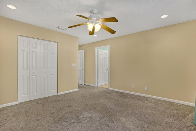 unfurnished bedroom featuring ceiling fan, a closet, carpet, and a textured ceiling