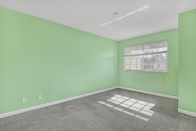 carpeted spare room with a textured ceiling