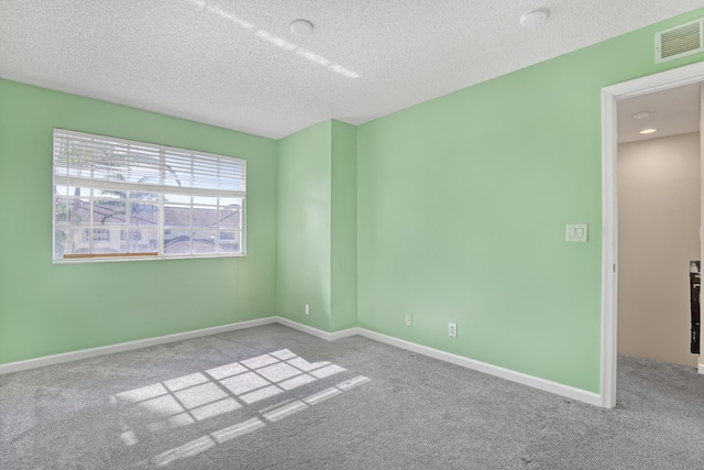 carpeted empty room with a textured ceiling