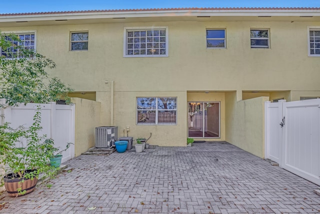 rear view of house with cooling unit and a patio area