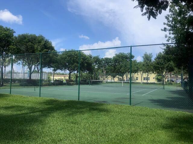 view of sport court featuring a lawn