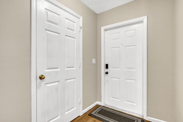 doorway to outside with hardwood / wood-style floors and a textured ceiling