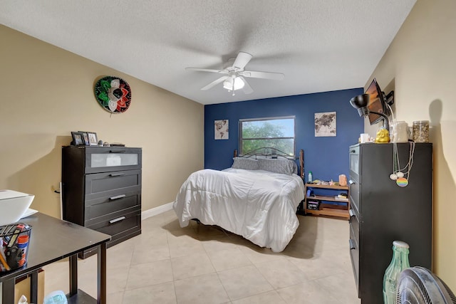 bedroom featuring ceiling fan, light tile patterned flooring, and a textured ceiling