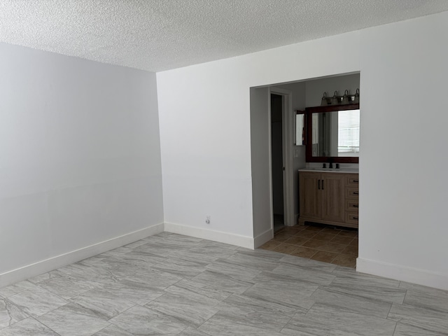 spare room featuring a textured ceiling and sink