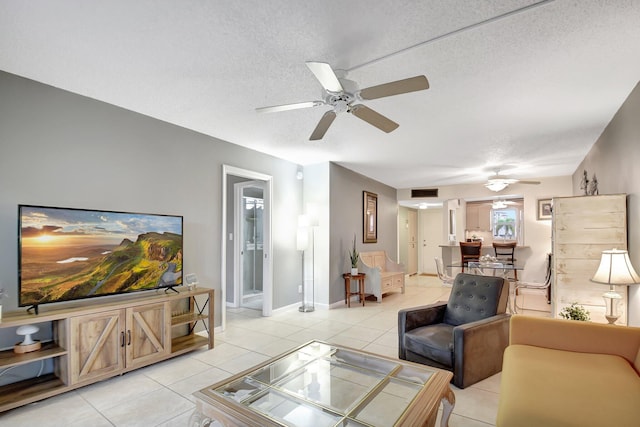 tiled living room featuring ceiling fan and a textured ceiling