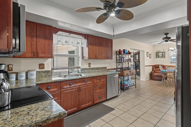 kitchen featuring stone counters, sink, light tile patterned floors, and appliances with stainless steel finishes