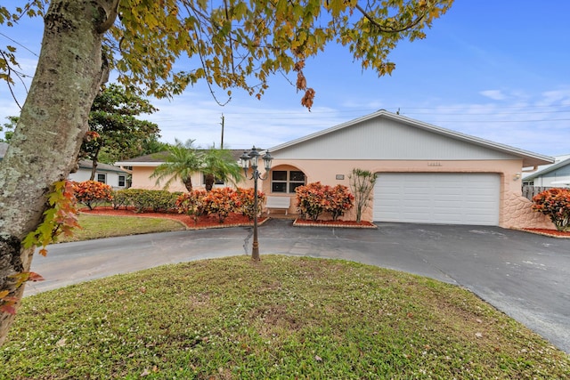 single story home with a front yard and a garage