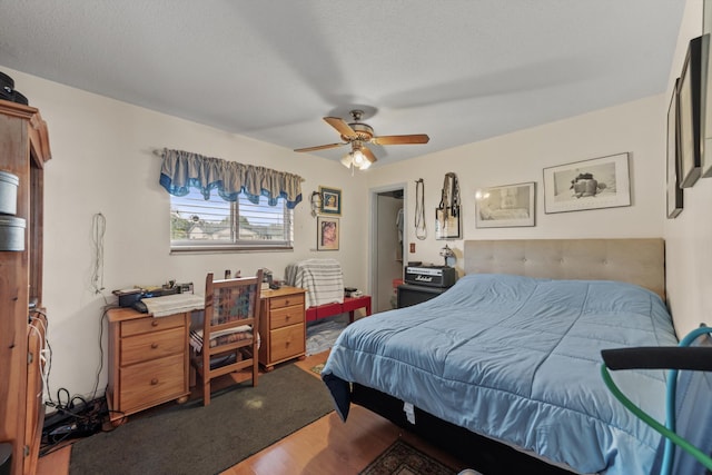 bedroom featuring wood-type flooring, a textured ceiling, and ceiling fan